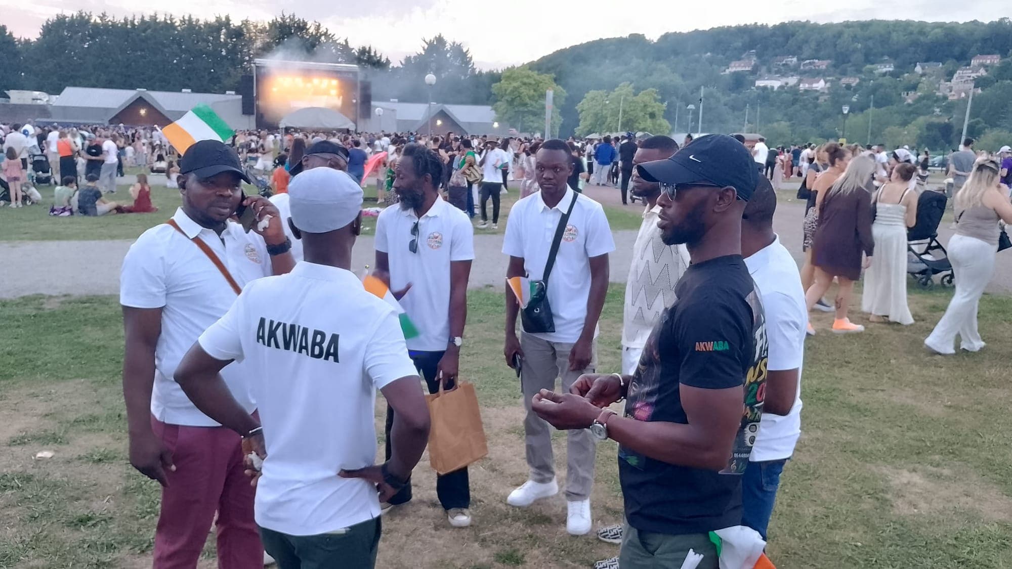 Des membres de l'association, en polos blancs floqués AKWABA, réunis lors d'un concert en plein air